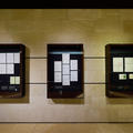 Three vertical display cases each showing a selection of handwritten pages