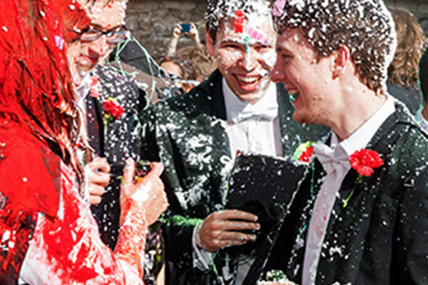 Closeup of Oxford students celebrating finishing exams by spraying foam and champagne