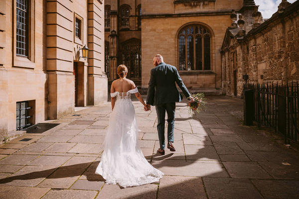 A bride and groom walk away from the camera