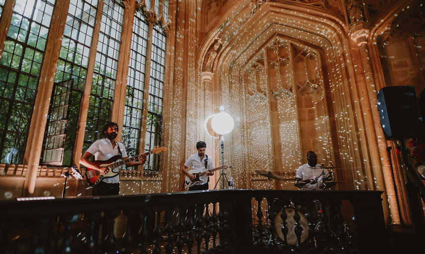 A three-piece band stand next to a large window with projected circles of light around them
