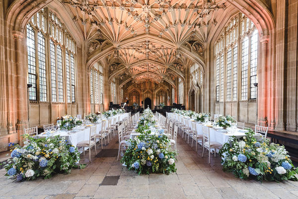 Three long tables decorated with blue and white flowers laid out at the Divinity School